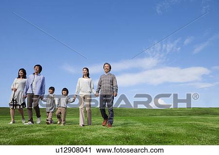 Stock Image - Three Generation Family Hand in Hand in Field. Fotosearch