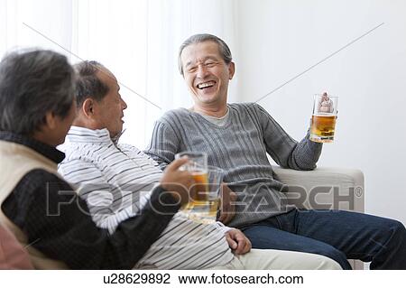 Stock Image - Three Senior Men Having Beer. Fotosearch