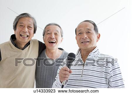 Stock Image - Three Senior Men Singing Karaoke. Fotosearch
