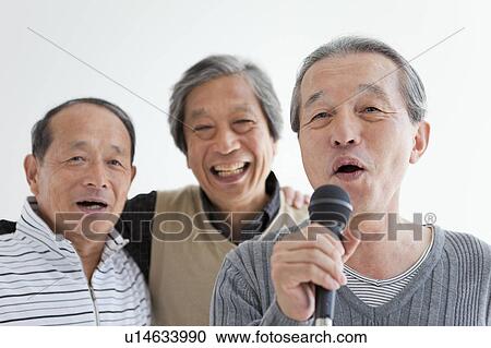 Stock Image - Three Senior Men Singing Karaoke. Fotosearch