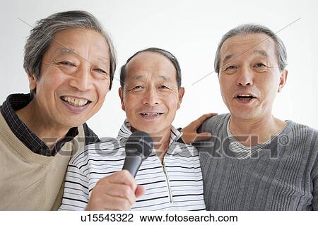 Stock Image - Three Senior Men Singing Karaoke. Fotosearch