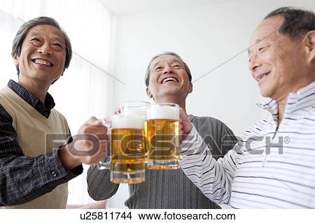 Picture - Three Senior Men Toasting with Pint. Fotosearch