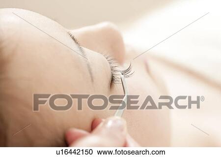 Stock Image - Woman Having Fake Eyelashes Put In. Fotosearch
