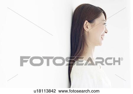 Stock Image - Woman Leaning Against Wall. Fotosearch