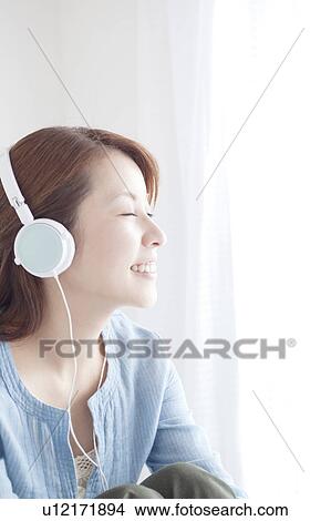 Picture - Woman Listening Music Through Headphones. Fotosearch