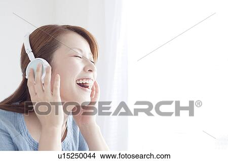 Picture - Woman Listening Music Through Headphones. Fotosearch