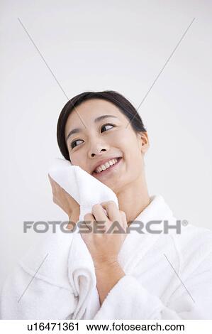 Stock Image - Woman wiping face with towel. Fotosearch