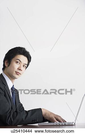 Picture - Young Businessman Using Laptop. Fotosearch