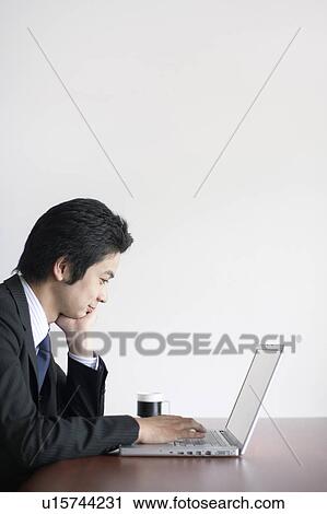 Stock Image - Young Businessman Using Laptop. Fotosearch