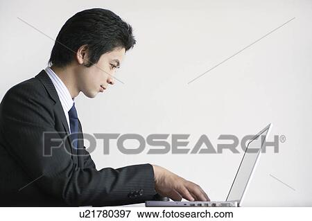 Stock Photo - Young Businessman Using Laptop. Fotosearch