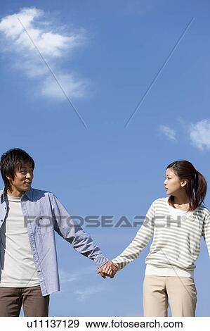 Stock Photo - Young Couple Against Blue Sky. Fotosearch