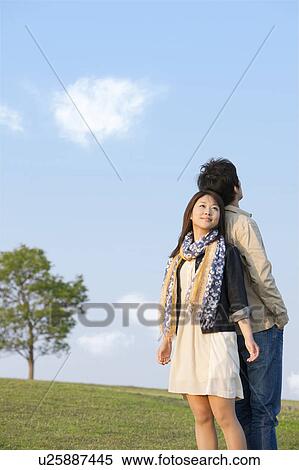 Young Couple Back to Back Against Blue Sky View Large Photo Image Stock Photography - Young Couple Back to Back Against Blue Sky. Fotosearch