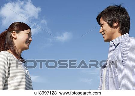 Young Couple Face to Face Against Blue Sky View Large Photo Image Stock Photo - Young Couple Face to Face Against Blue Sky. Fotosearch