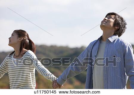 Young Couple Holding Hands and Looking Up View Large Photo Image Stock Photography - Young Couple Holding Hands and Looking Up. Fotosearch