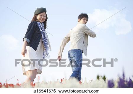 Stock Photograph - Young Couple in Field of Flowers. Fotosearch