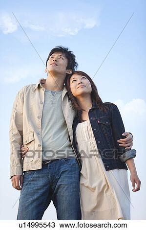 Stock Image - Young Couple Looking Up. Fotosearch
