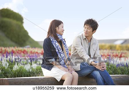 Stock Photo - Young Couple Sitting on Bench. Fotosearch