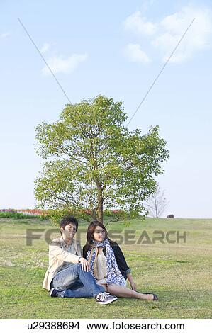 Young Couple Sitting on Grass View Large Photo Image Picture - Young Couple Sitting on Grass. Fotosearch