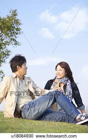 Stock Image - Young Couple Sitting Outdoors. Fotosearch