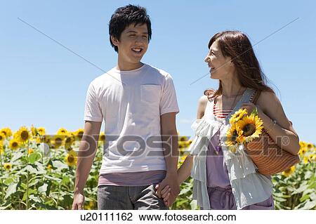 Young Couple Walking in Sunflower Field View Large Photo Image Stock Image - Young Couple Walking in Sunflower Field. Fotosearch