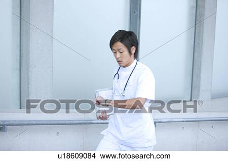Picture - Young Male Doctor Checking The Time. Fotosearch