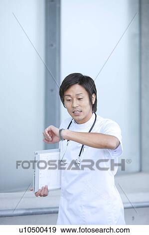 Young Male Doctor Checking The Time View Large Photo Image Stock Photo - Young Male Doctor Checking The Time. Fotosearch