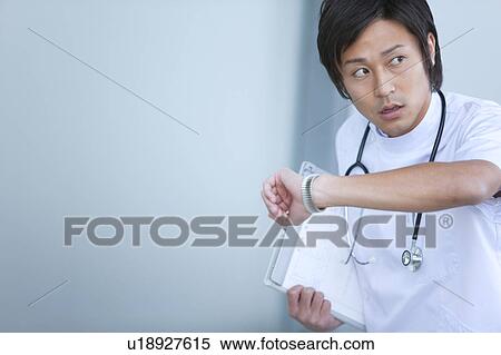Young Male Doctor Checking The Time View Large Photo Image Stock Photography - Young Male Doctor Checking The Time. Fotosearch