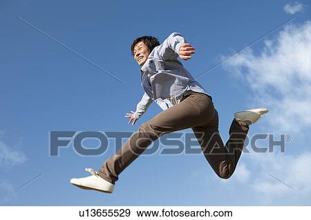 Stock Photo - Young Man Jumping Mid Air. Fotosearch