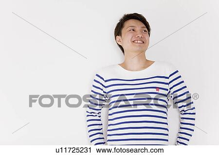 Young man looking away and smiling View Large Photo Image Stock Image - Young man looking away and smiling. Fotosearch