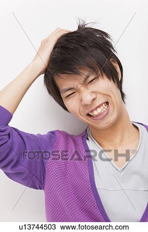 Stock Image - Young man with head in hands. Fotosearch