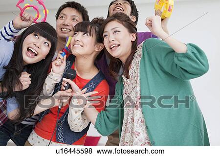 Stock Photo - Young people singing karaoke. Fotosearch