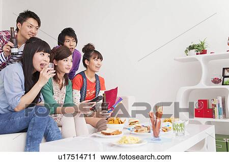Stock Image - Young people watching TV. Fotosearch