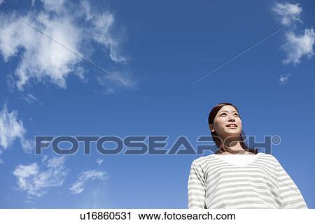 Stock Image - Young Woman Against Blue Sky. Fotosearch