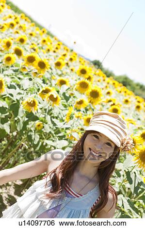 Stock Photograph - Young Woman in Sunflower Field. Fotosearch