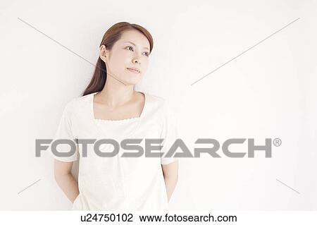 Stock Image - Young Woman Leaning Against Wall. Fotosearch