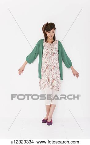 Picture - Young woman leaning on wall. Fotosearch
