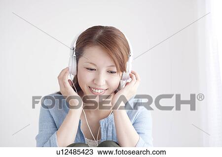 Stock Image - Young Woman Listening To Headphones. Fotosearch