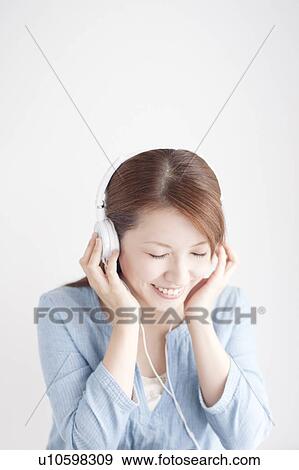 Young Woman Listening To Headphones View Large Photo Image Stock Photo - Young Woman Listening To Headphones. Fotosearch