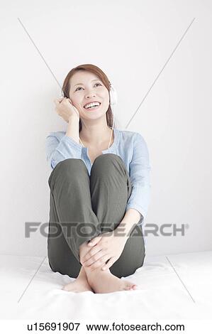 Stock Photo - Young Woman Listening To Headphones. Fotosearch