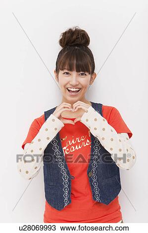 Young woman making a heart shape with hands View Large Photo Image Stock Image - Young woman making a heart shape with hands. Fotosearch