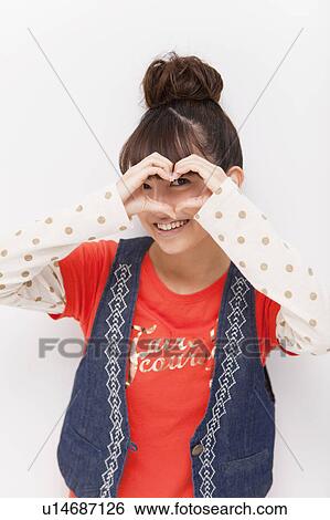 Young woman making a heart shape with hands View Large Photo Image Stock Photograph - Young woman making a heart shape with hands. Fotosearch