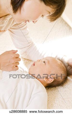 Stock Photography - Baby and mother looking at each other. Fotosearch