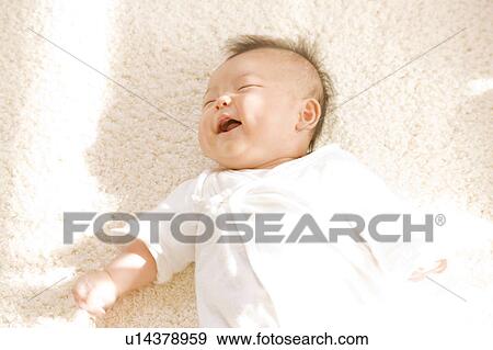 Stock Photo - Baby lying down and smiling. Fotosearch