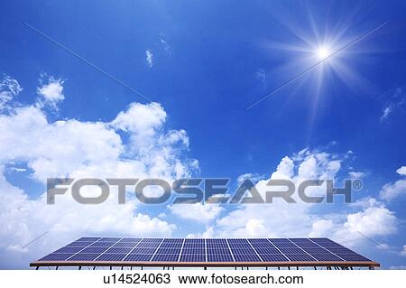 Stock Image - Blue Sky and Sun Over Solar Panels. Fotosearch