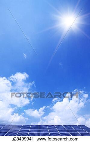 Stock Image - Blue Sky and Sun Over Solar Panels. Fotosearch