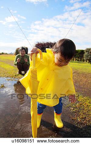 Boy in Yellow Raincoat, Grandmother in Background View Large Photo Image Stock Image - Boy in Yellow Raincoat, Grandmother in Background. Fotosearch