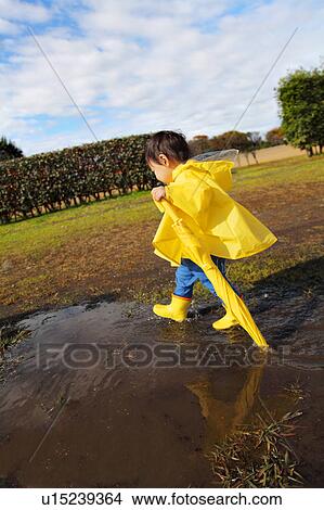 Boy in Yellow Raincoat Walking View Large Photo Image Picture - Boy in Yellow Raincoat Walking. Fotosearch