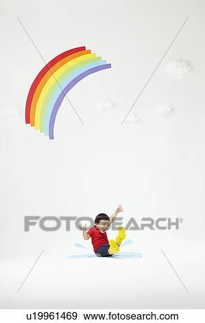 Stock Photo - Boy Splashing Water Under Rainbow. Fotosearch