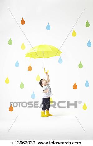 Stock Photo - Boy Under Umbrella in Colourful Rain. Fotosearch