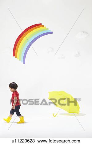 Stock Photo - Boy Walking Away From Umbrella, Rainbow Above. Fotosearch